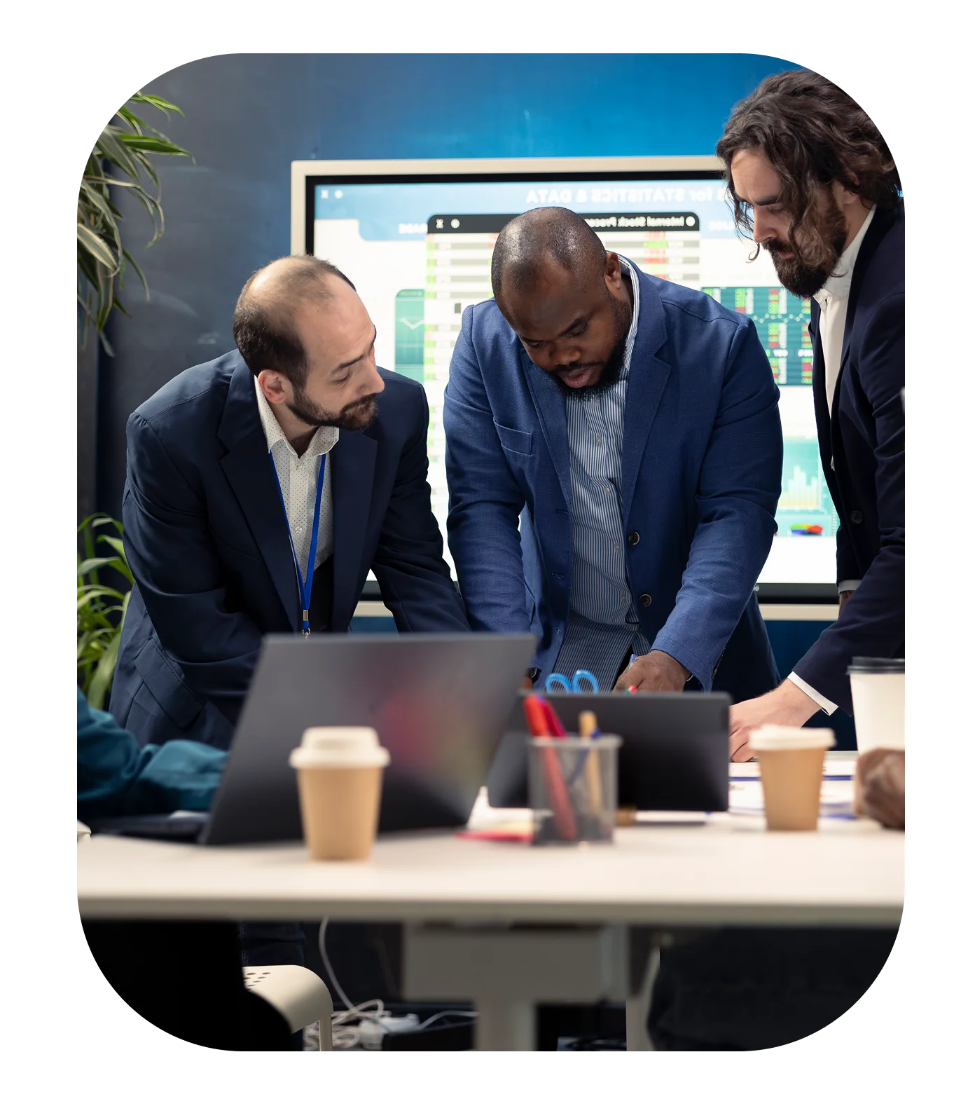 Three men collaborating in an office meeting.