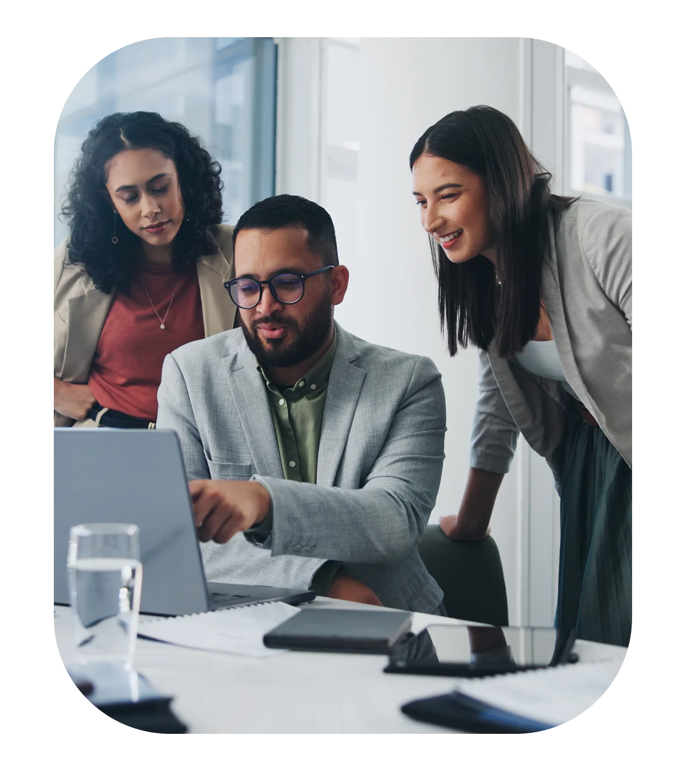 Three colleagues collaborating at a laptop.
